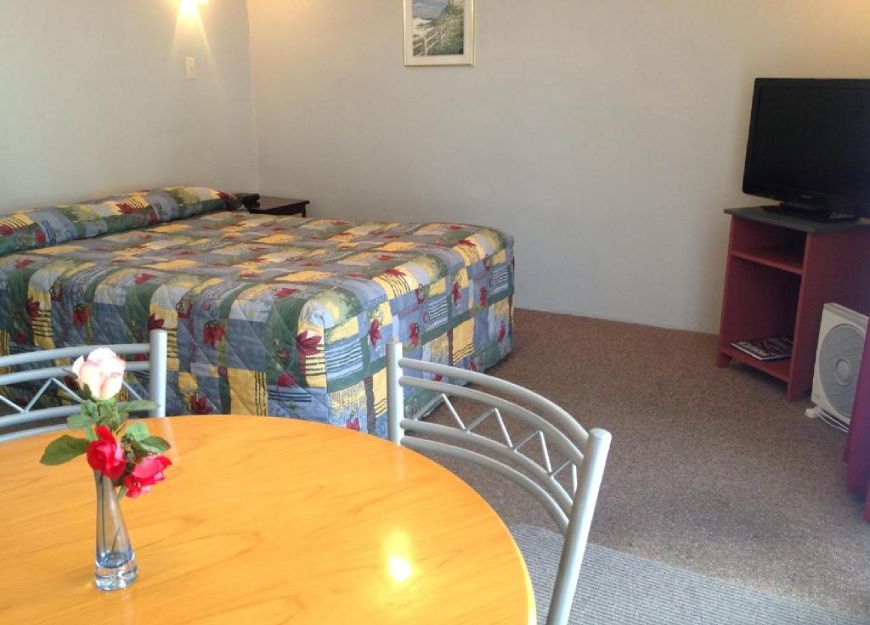 Spacious and modern motel room with queen-size bed in Hastings